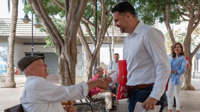 Hernández saluda a un vecino en un reparto informativo junto a compañeros y compañeras del PSOE de la capital